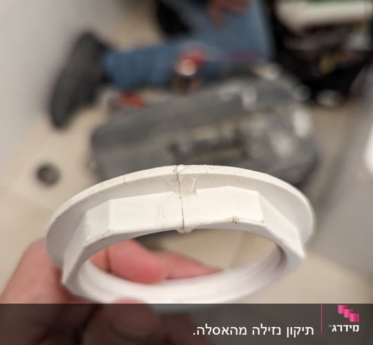 טבעת פלסטיק לבנה מוחזקת ביד של אינסטלטור
